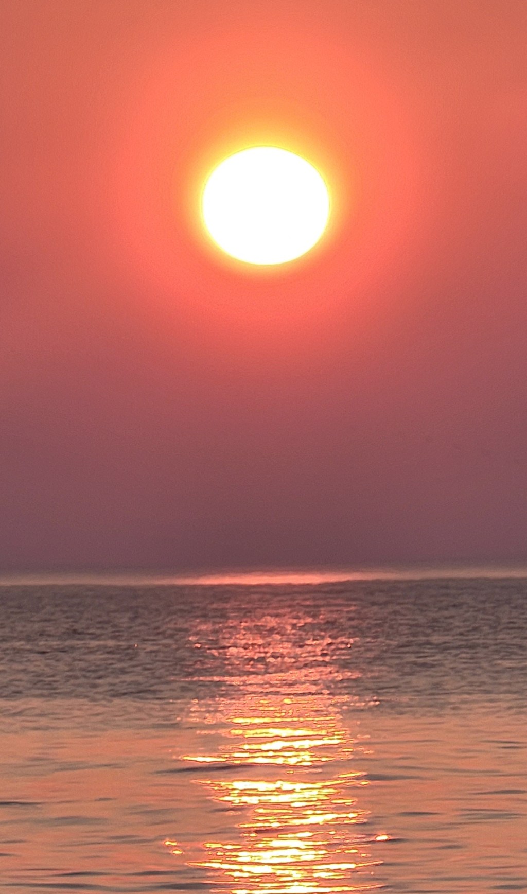 orang ball of the sun set reflecting on the rippled surface of Lake Superior